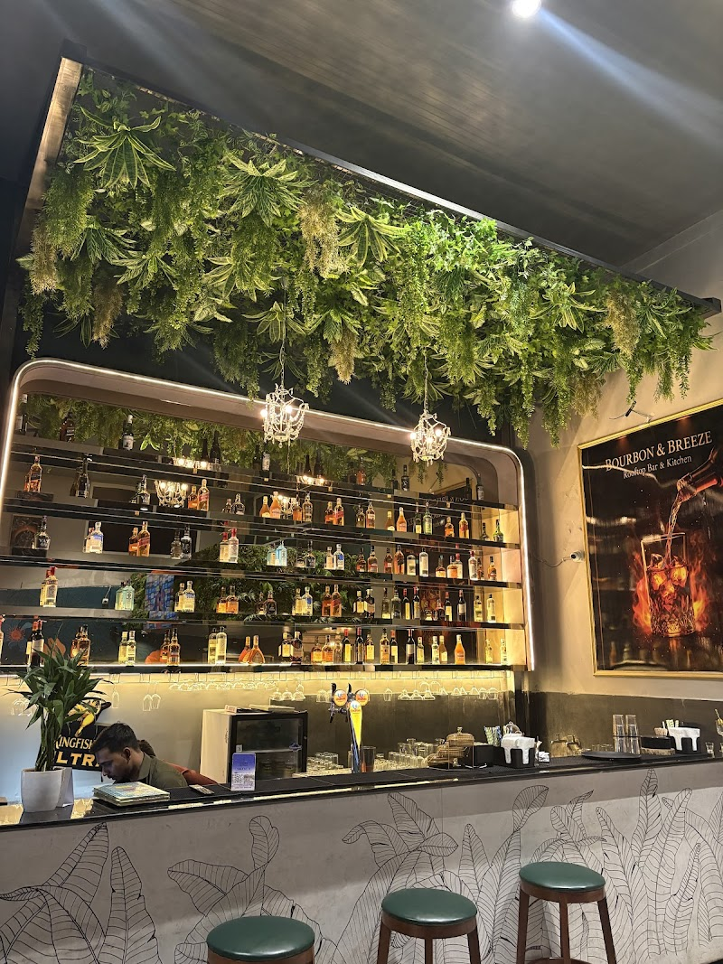 Rooftop bartender pouring a cocktail under warm pendant lights